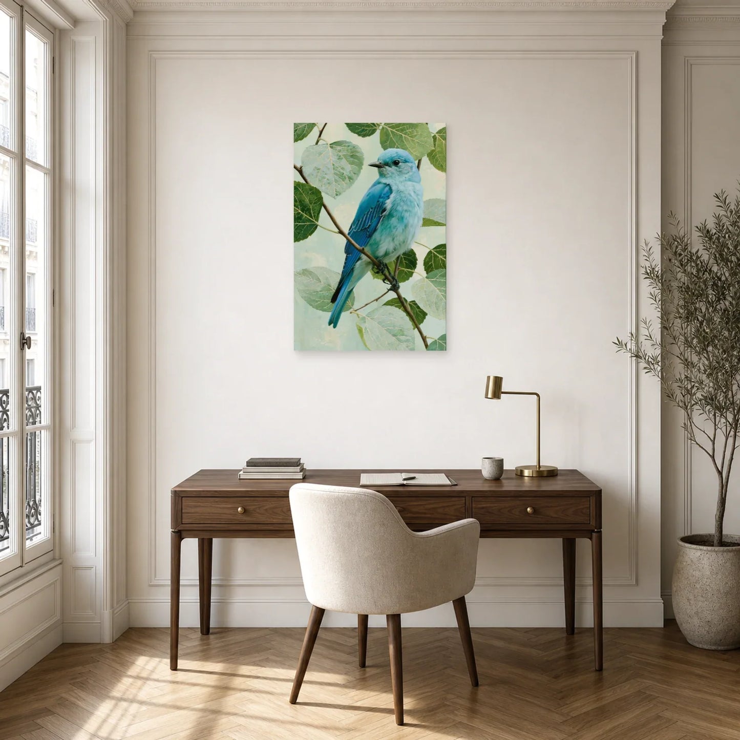 Tableau oiseau bleu sur branche avec feuillage vert pale dans un bureau élégant