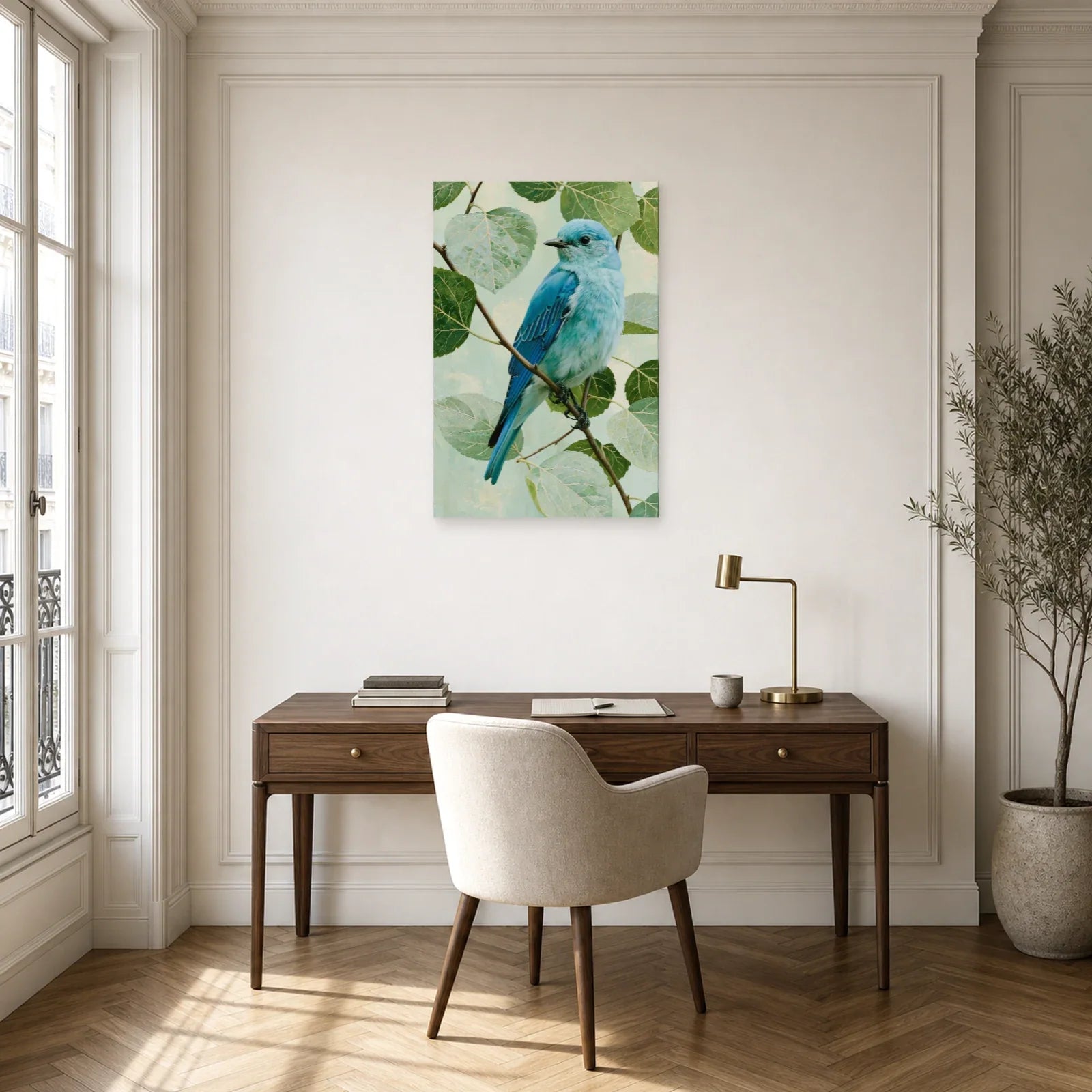 Tableau oiseau bleu sur branche avec feuillage vert pale dans un bureau élégant